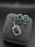 Silver necklace and earring set with emerald green rectangular stone and baguette crystal halo.