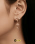 Close-up of a model wearing elegant gold-plated heart-shaped jhumka earrings with a crystal drop.