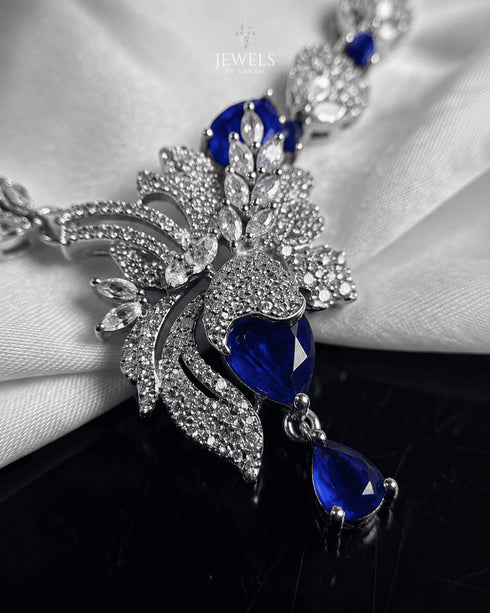 "Close-up of sapphire blue stones and feather pendant design on AD necklace by Jewels by Sarah"