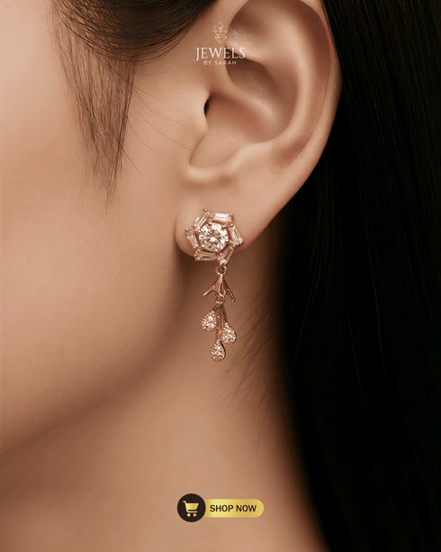 Close-up of a model wearing radiant rose gold Zircon blossom earrings with a dangling floral tassel design.