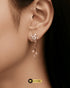 Close-up of a model wearing radiant rose gold Zircon blossom earrings with a dangling floral tassel design.