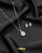 Baby pink teardrop pendant necklace and matching stud earrings on black silk.