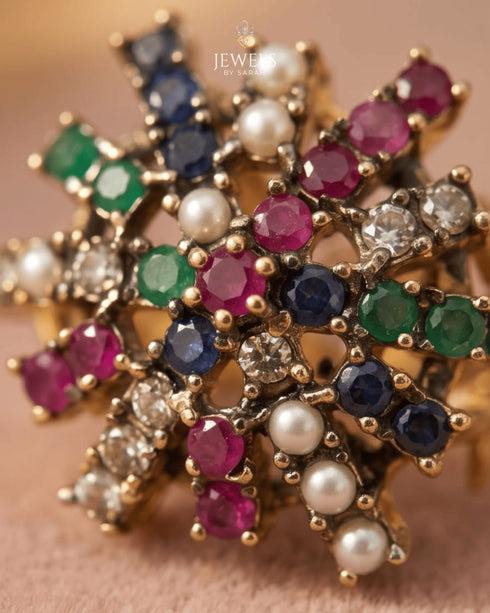 "Close-up of ruby, sapphire, emerald and pearl starburst design on antique gold jewelry by Jewels by Sarah"