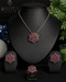 The complete luxury ruby red signature collection set featuring the necklace, earrings, and ring arranged on a professional black jewelry display stand.
