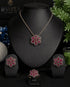 The complete luxury ruby red signature collection set featuring the necklace, earrings, and ring arranged on a professional black jewelry display stand.