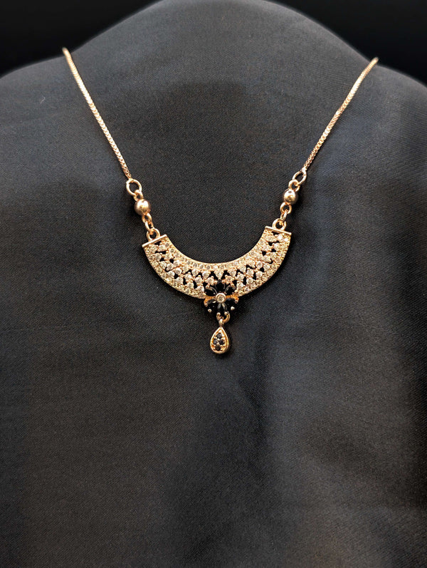 Rose gold filigree crescent necklace with midnight black stone floral center and matching black teardrop dangle.