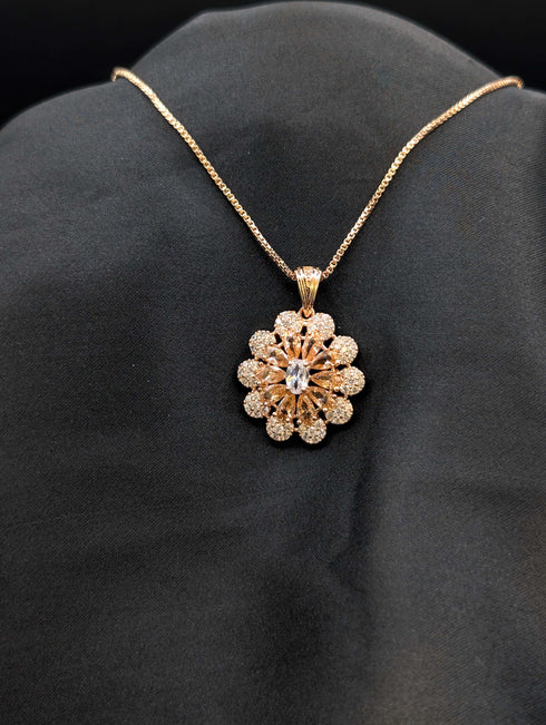 Rose gold floral medallion necklace featuring champagne and white cubic zirconia stones in a sunflower pattern on a black background.