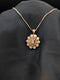 Rose gold floral medallion necklace featuring champagne and white cubic zirconia stones in a sunflower pattern on a black background.