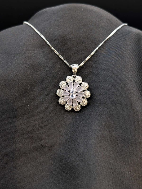Silver-plated floral medallion necklace with pastel lavender and white cubic zirconia stones in a sunflower pattern on a black background.