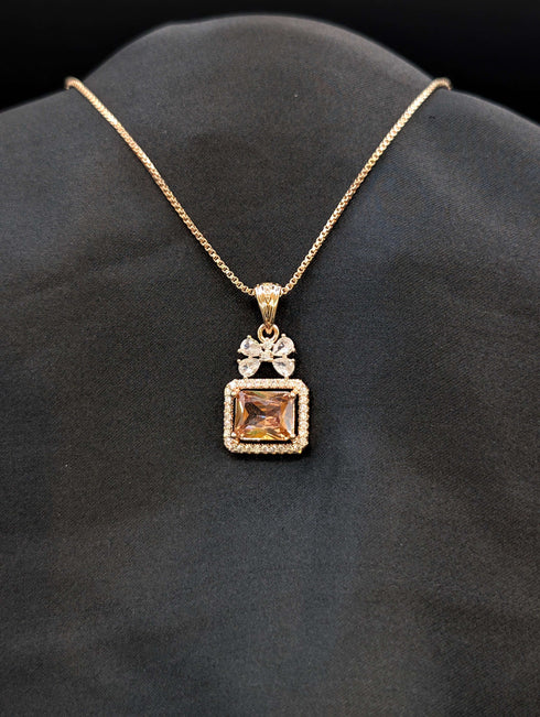 Rose gold necklace featuring a rectangular champagne-colored stone pendant with a crystal halo and a butterfly-shaped stone bail on a black background.