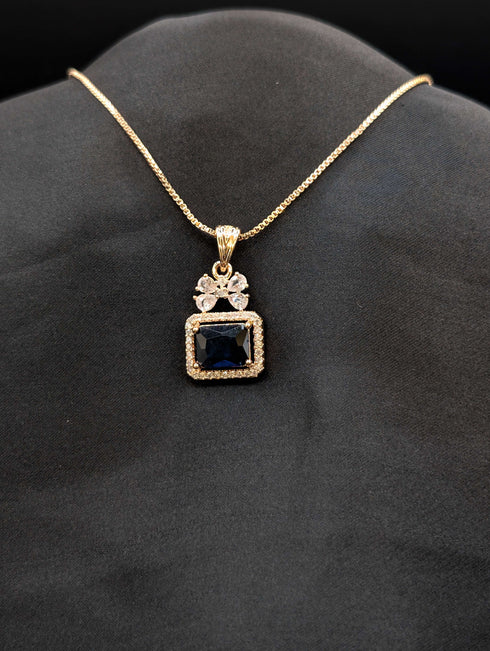 Rose gold necklace featuring a rectangular midnight blue stone pendant with a crystal halo and a butterfly-shaped stone bail on a black background.