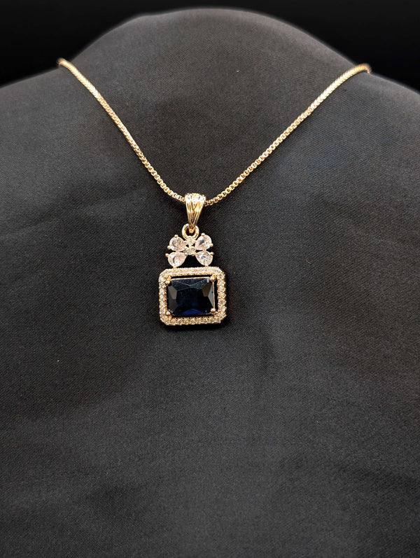 Rose gold necklace featuring a rectangular midnight blue stone pendant with a crystal halo and a butterfly-shaped stone bail on a black background.