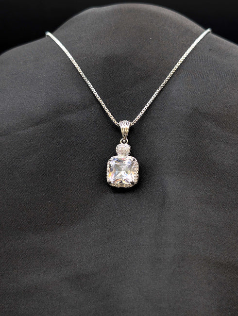 Silver-plated necklace featuring a brilliant clear cushion-cut square pendant with a micro-pavé stone halo on a black background.