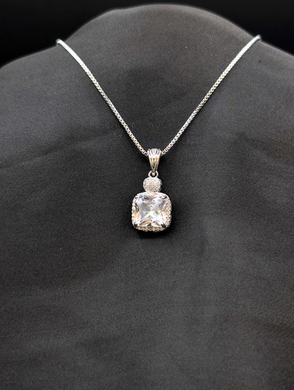Silver-plated necklace featuring a brilliant clear cushion-cut square pendant with a micro-pavé stone halo on a black background.