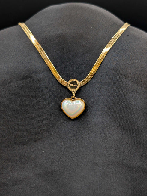 Gold-plated stainless steel herringbone flat snake chain necklace with an iridescent heart pendant and engraved "Love" circular bail.