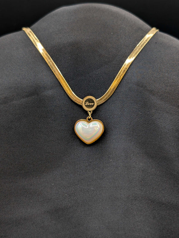 Gold-plated stainless steel herringbone flat snake chain necklace with an iridescent heart pendant and engraved "Love" circular bail.