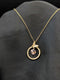 Gold-plated stainless steel necklace featuring a circular pave halo pendant with a butterfly accent and a floating crystal cube center.