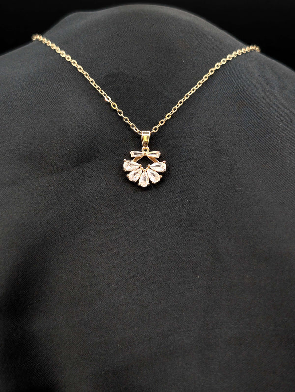 Gold-plated stainless steel necklace with a fan-shaped sunburst pendant featuring pear-cut crystals on a black background.