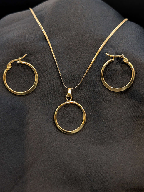 Gold-plated stainless steel jewelry set featuring a circular halo pendant on a snake chain and matching gold hoop earrings on a black background.