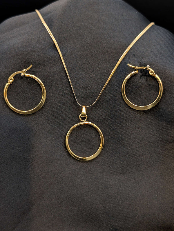Gold-plated stainless steel jewelry set featuring a circular halo pendant on a snake chain and matching gold hoop earrings on a black background.