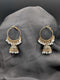 Gold-toned Jhumka hoop earrings featuring a filigree bell pendant and a fringe of white pearls on a dark grey background.