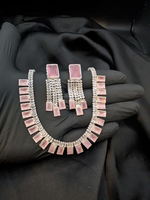 Close-up of a blush pink 1 Karat Zircon necklace and earring set for romantic styling.