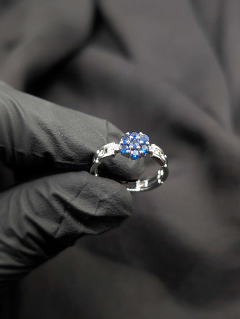 Detailed view of the floral stone setting and side accent stones on a silver-tone link-style statement ring.