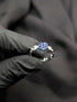 Detailed view of the floral stone setting and side accent stones on a silver-tone link-style statement ring.