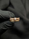 Rose gold statement ring with a stacked 3-tier design featuring a clear solitaire stone and geometric criss-cross bands.