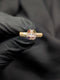 Gold statement ring featuring a rectangular clear baguette-cut center surrounded by multi-colored round gemstones.