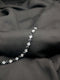 Polished silver-tone tennis bracelet with alternating black onyx and clear white princess-cut crystals on a dark textured background.
