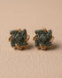 Gold plated emerald stone stud earrings pair on beige leather background