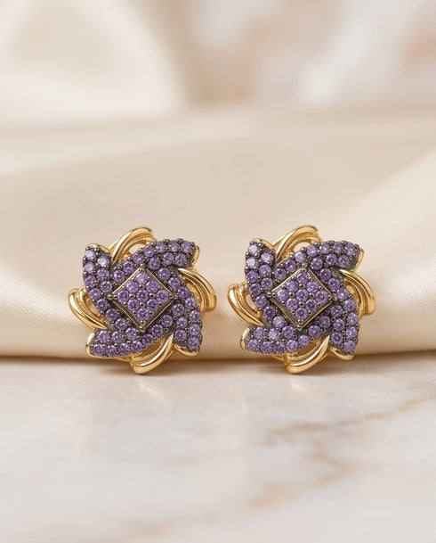 22K gold plated purple stone floral stud earrings on beige fabric