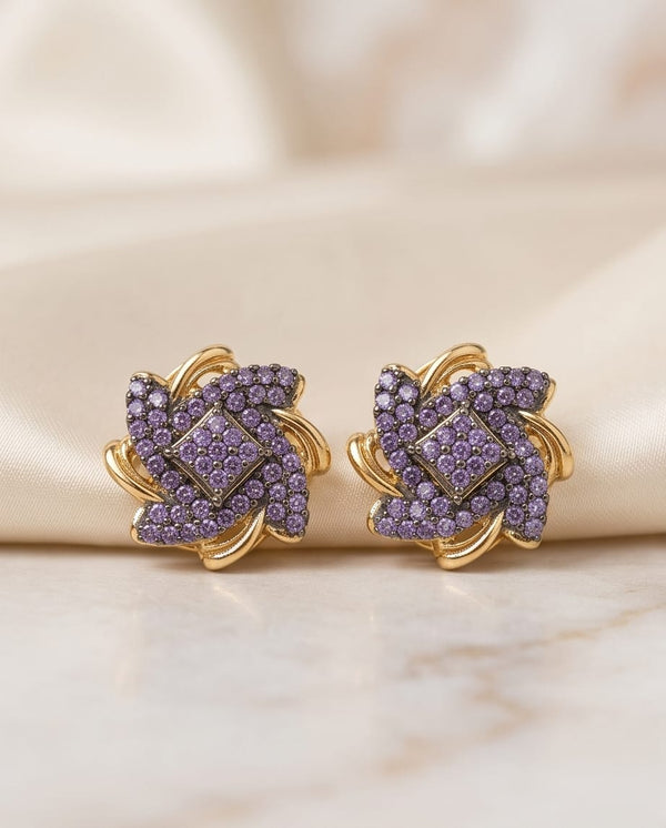 22K gold plated purple stone floral stud earrings on beige fabric