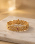 South Indian gold plated floral bangle with ruby and white stones on marble