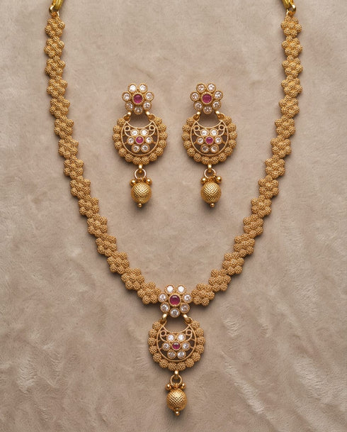 South Indian gold polish necklace and earring set flatlay on beige fabric