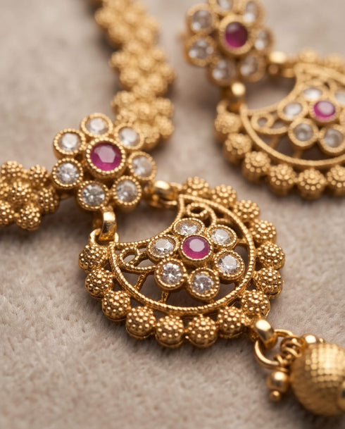 Close up of South Indian chandbali earrings with ruby and white stone detail