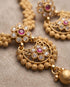 Close up of South Indian chandbali earrings with ruby and white stone detail