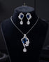 Jewelry set with necklace and earrings featuring blue gemstones on a black background.
