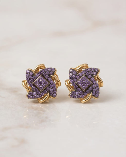 Purple stone gold plated floral stud earrings pair on marble background