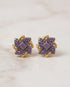 Purple stone gold plated floral stud earrings pair on marble background