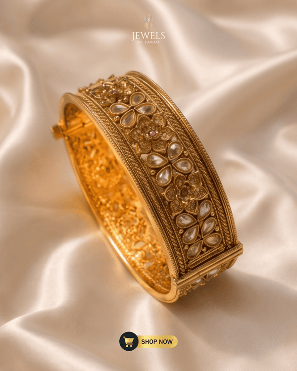 Jewels by Sarah 24K gold plated broad signature bangle with floral AD stone carvings on cream silk.